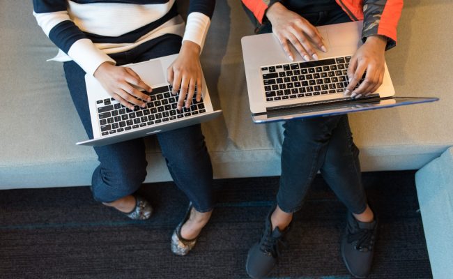 Two People Holding Macbook Pro